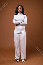 Young beautiful African Zulu businesswoman against brown backgro