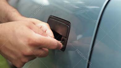 Male Mechanic Holding Lockpicker To Open Car Door
