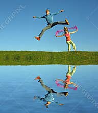 Couples jump on grass