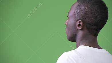 Rear view of young African man against green background