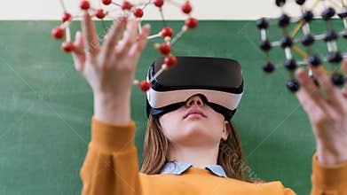 Female student wearing virtual reality glasses, holding molecular structure model. Science class, Education, VR, New Technologies.