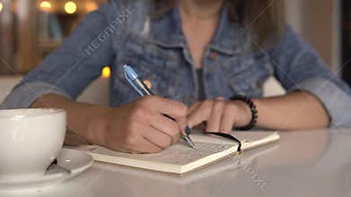 Woman writing in journal, diary