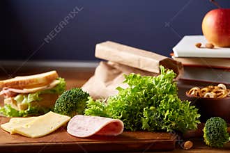Back to School concept, school supplies, biscuits, packed lunch and lunchbox on white desk, selective focus, close-up.