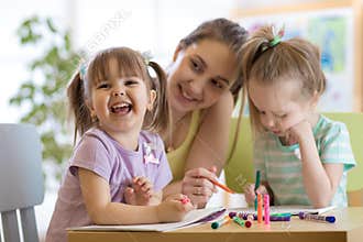 Female teacher working with kids in preschool classroom