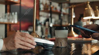 Close-up shot of unrecognizable man using mobile phone nfc payment banking in order to pay for to go coffee at lovely