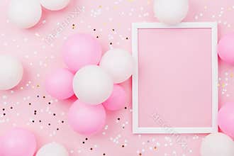Birthday mockup with frame, pastel balloons and confetti on pink table top view. Flat lay composition.