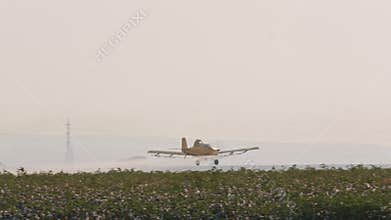 Crop duster spraying chemicals over a cotton field - slow motion
