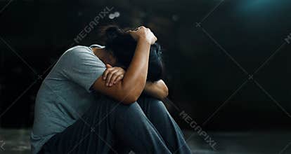 PTSD Mental health concept. Post Traumatic Stress Disorder. The depressed woman sitting alone on the floor in the dark room backgr