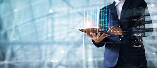 Businessman using tablet analyzing sales data and economic.