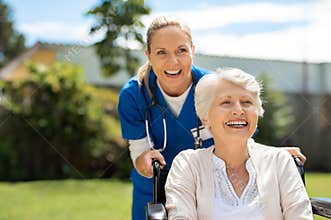 Woman on wheelchair having fun with nurse