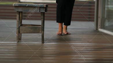 A woman walking barefoot on a wooden floor