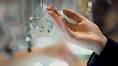 Female hand holding diamond pendant, jewelry assortment in luxury shopping mall