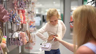 Happy family doing shopping. Family in mall. Mother and little daughter shopping for girls clothes in a clothing store
