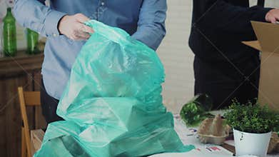 Man in office putting paper waste in recycling bag