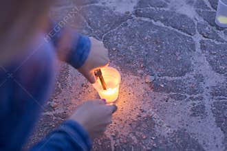 A woman lights a candle. Day of Remembrance for the Bereaved