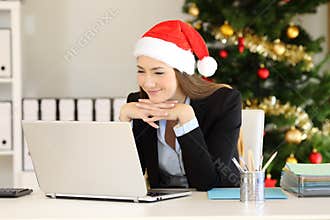 Satisfied office worker reading on line in christmas