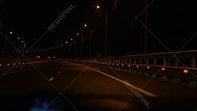 The car moves at night along the road.