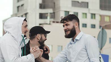 Gay man gave five to a friend close-up. Adult young guys are laughing closeup.
