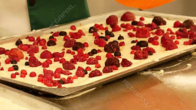 The baker added raspberries and currants to the cake.