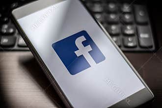 Facebook page on the smartphone on table