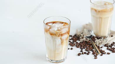 Concept of coffee and cocktails. Cream poured into coffee with ice