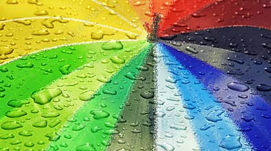 Waterdrops on rainbow coloured parasol