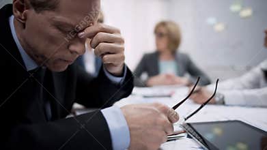 Business worker feeling bad headache at meeting, work frustration and stress