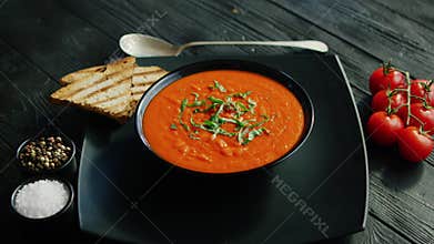 Tomato soup in bowl with crisp bread
