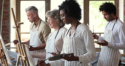 Multicultural diverse group of persons take lesson at art school