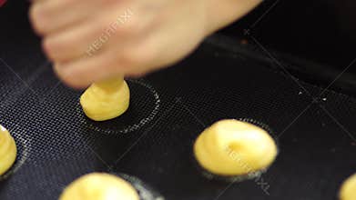 Female hands squeeze custard crackle out of a pastry bag
