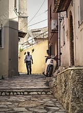 Old man and bike in alley in old, greek village.