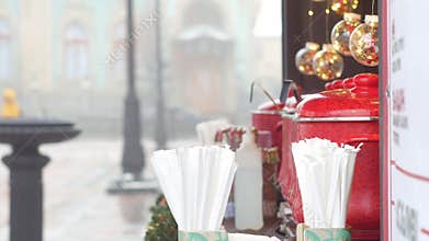 Red pots with mulled wine on Christmas market illuminated stall. Seasonal holiday street food beverages concept New year