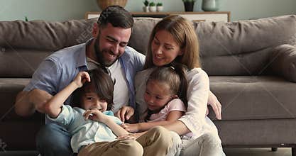 Bonding family couple with little kids messing tickling on floor