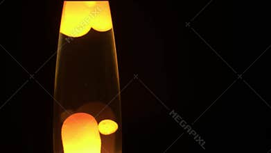 Lamp wax in dynamic motion floating in liquid on black background for copy space look down camera