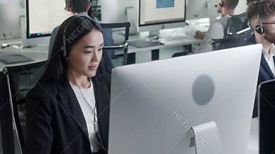 Portrait of a Technical Customer Support Specialist Talking on a Headset while Working on a Computer in Call center and