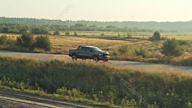 Big pickup truck Dodge Ram TRX driving on an asphalt road.