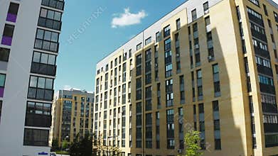 A sunny daytime exterior of a typical upscale apartment building. Stock footage. Aerial view of a summer city street