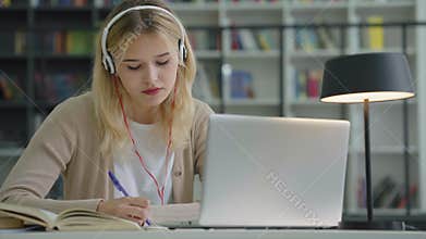 Young female having video call studying online in library