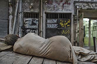 An old man sleeps during the day on the freight cart.