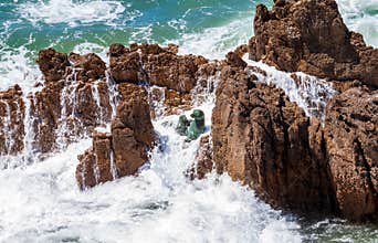 Waves crashing on rocks with sea lion sculpture