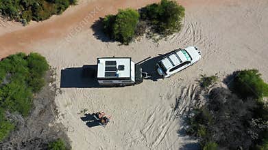 Australian couple relaxing during a beach holiday with 4WD vehicle and caravan