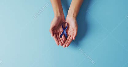 Video of biracial female doctor holding blue colon cancer ribbon