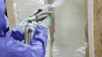 Builder apply insulating foam on the wall of a wooden house, foam insulation