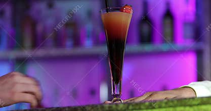 Bartender gives a cocktail to a girl