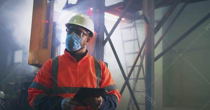 Male supervisor in mask using tablet near worker