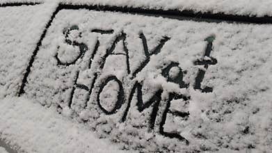 Stay at home words on car snowy window