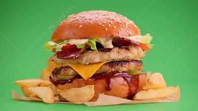 Yummy cheeseburger and fries rotation on a green screen background.