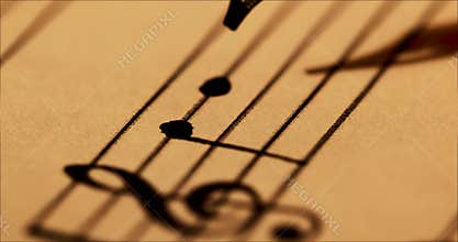 Writing musical notes with quill pen and ink