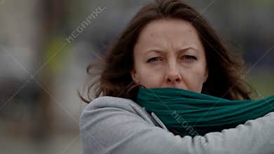 depressive middle-aged woman on street in city, portrait shot outdoors, sad face