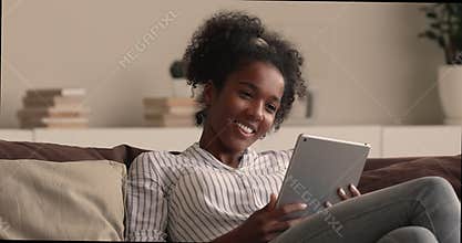 Happy millennial african american woman using digital tablet.